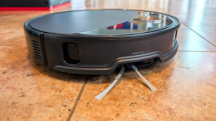 Close-up of a Roborock Saros 10R robot vacuum showing its sleek design and FlexiArm Riser feature on a tiled floor.