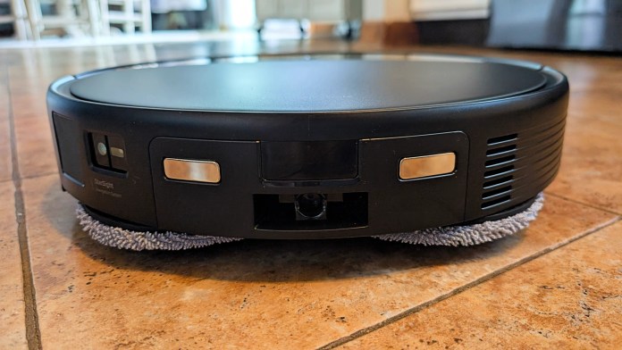 Close-up view of the Roborock Saros 10R robot vacuum and mop, showcasing its sleek design, integrated sensors, and cleaning pads against a tiled floor.