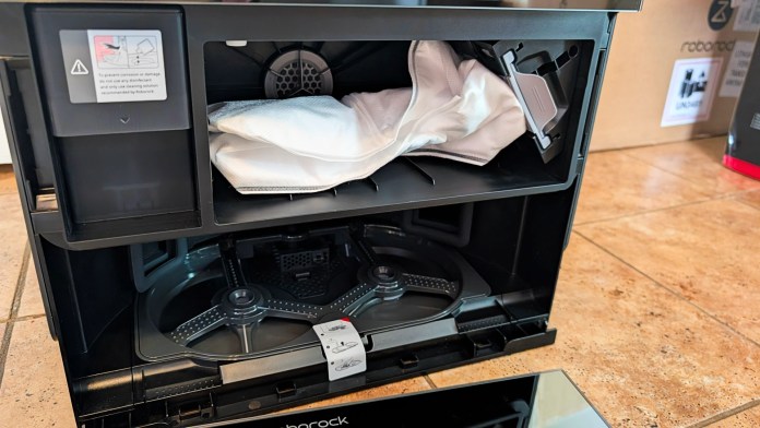 Interior view of the Roborock Saros 10R dock showing the compartment for storing mop pads and its internal components.