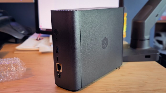 Side view of the Synology BeeStation Plus showing its ports and design on a desk.
