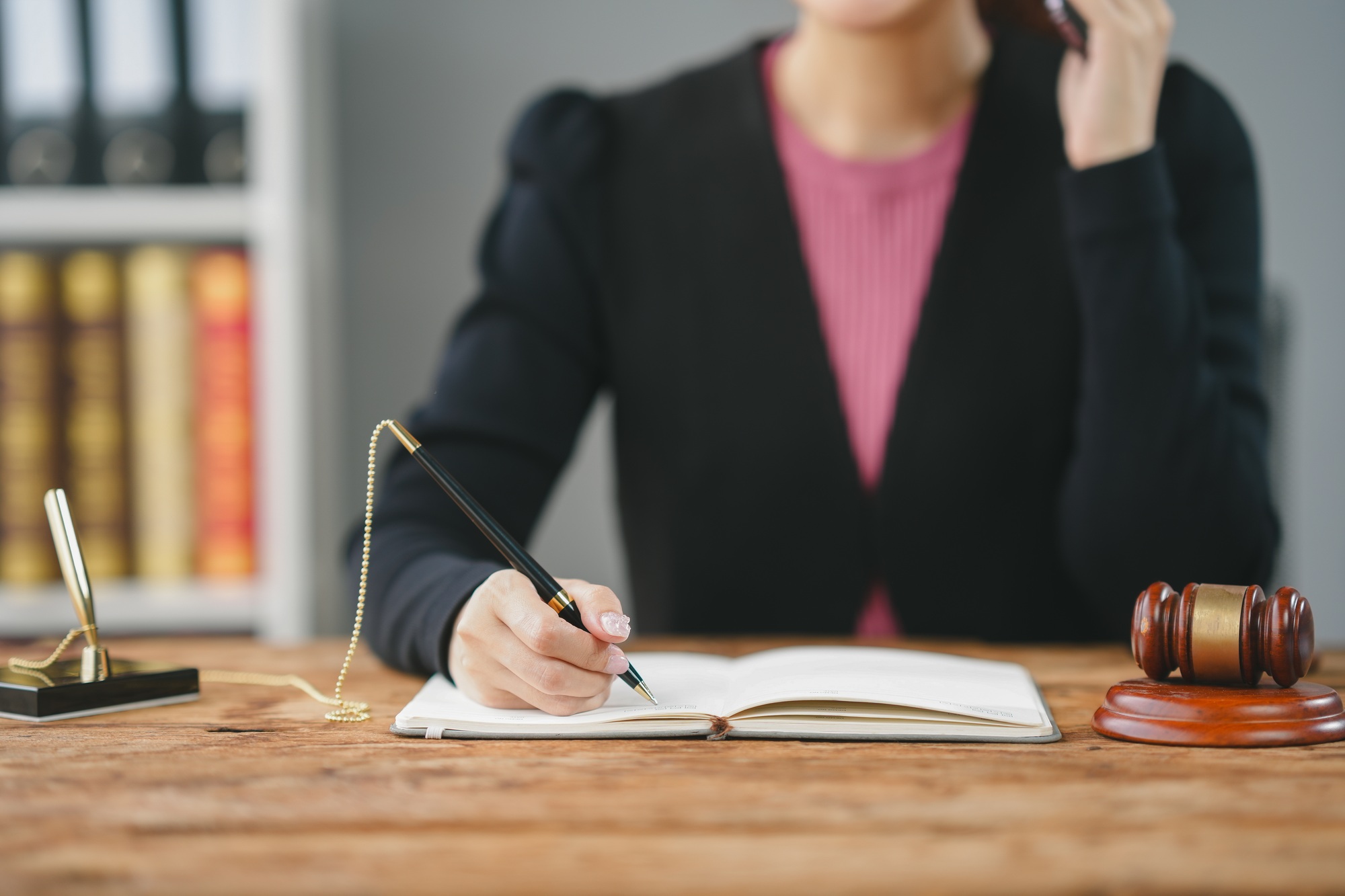 Professional at desk with gavel, notebook, and phone, symbolizing legal work