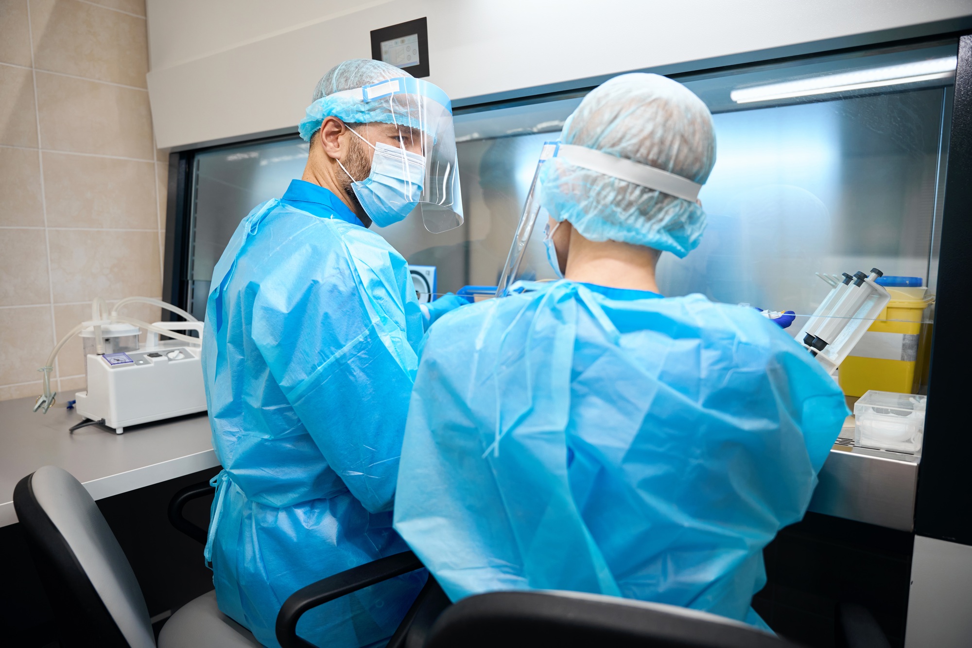 People in laboratory work with biomaterial in compliance with safety precautions