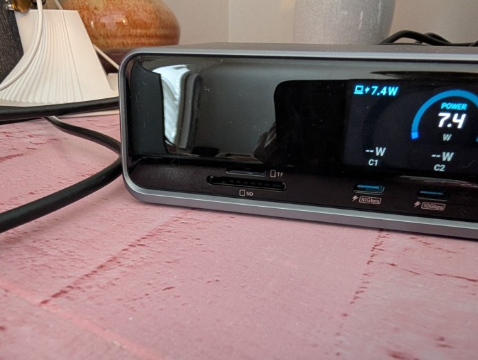 Close-up view of the Anker Prime Docking Station showcasing its LED display, microSD and full-sized SD card slots, and USB-C ports on a textured surface.