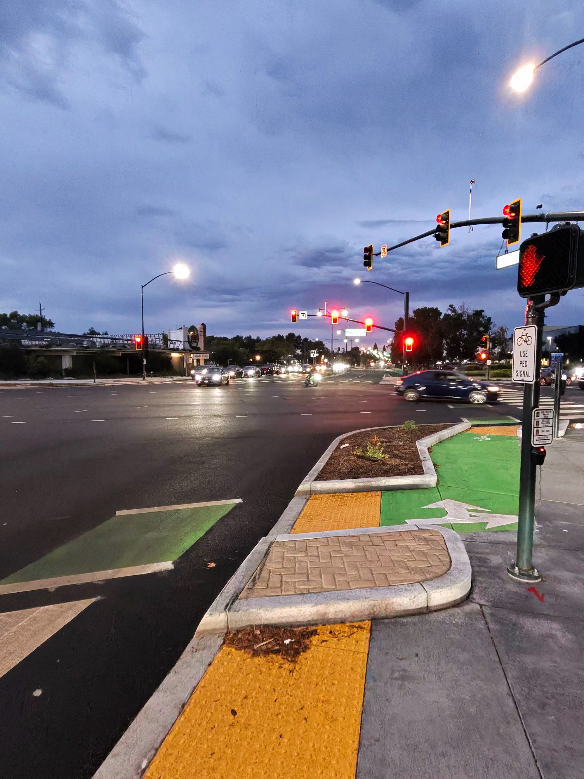 A photo taken with the Ray-Ban Meta (Gen 2) smart glasses showing an intersection with moving cars on a cloudy evening.
