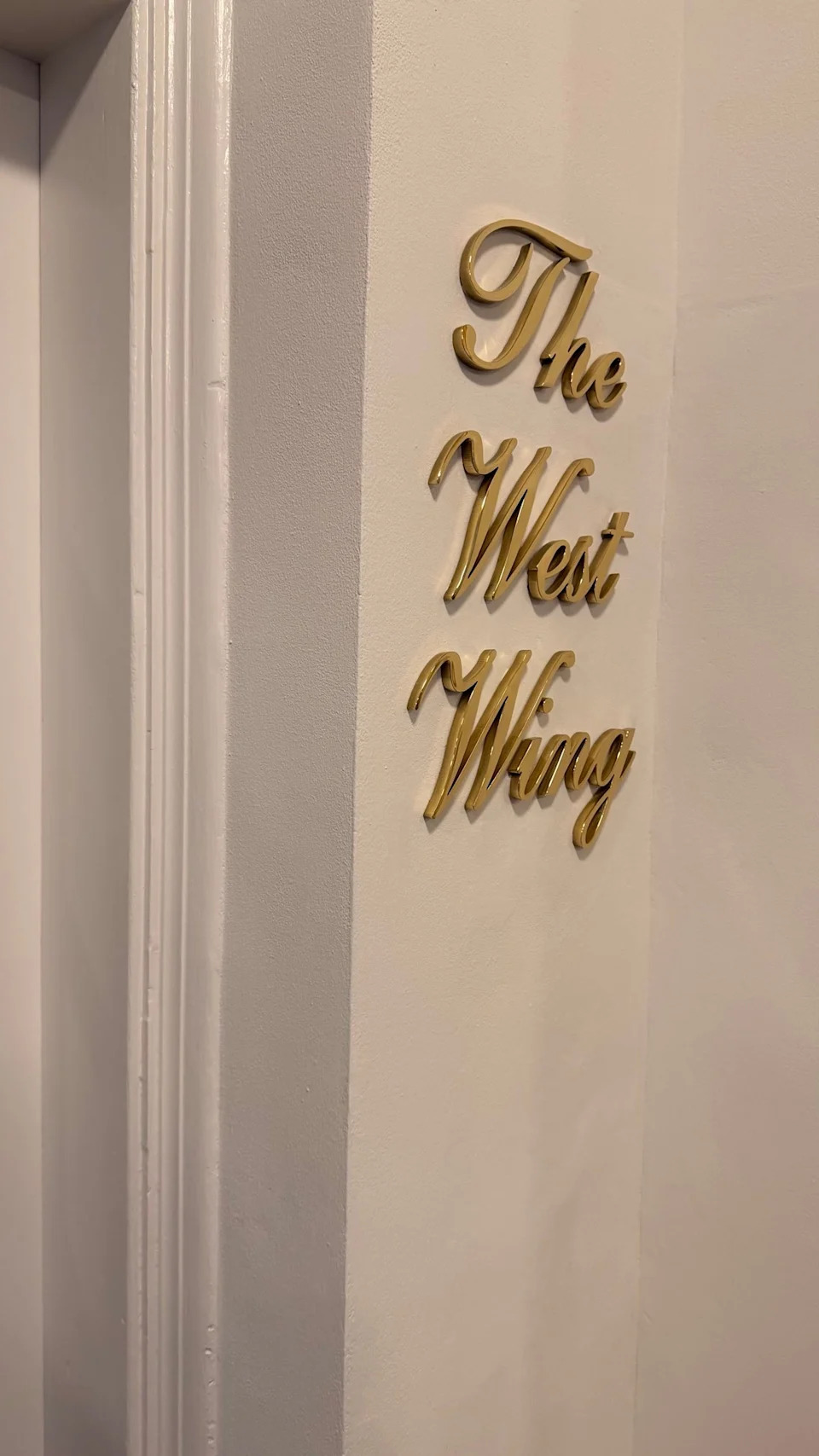 Gold text on a wall reads "The West Wing."